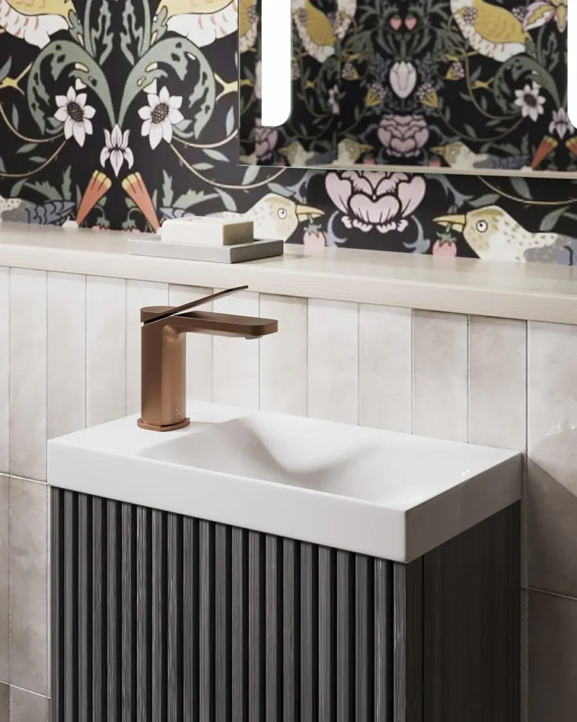 A stylish bathroom features a sleek faucet, decorative sink, and vibrant, bird-themed wallpaper with floral patterns, creating a modern and artistic ambiance.