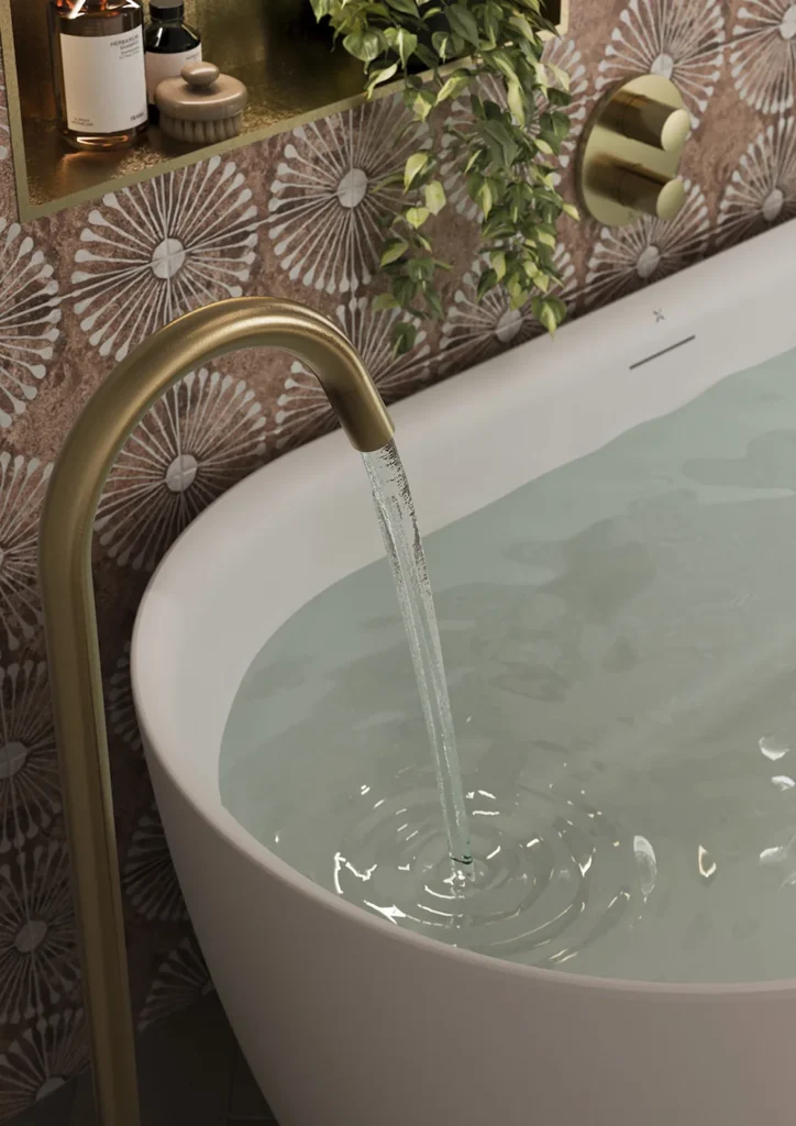 A luxurious bathroom features a freestanding tub with water flowing from a gold faucet. Decorative tiles and greenery provide elegant ambiance.