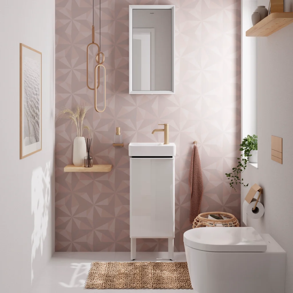 A stylish bathroom features geometric wallpaper, a compact sink, modern fixtures, wall art, hanging light, and a woven rug, creating a cozy ambiance.